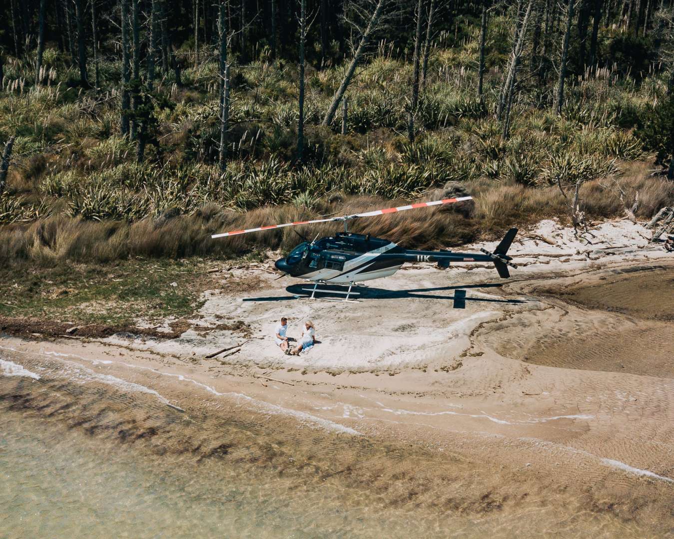 Helicopter parked at a secluded beach during a Bay of Plenty scenic flight